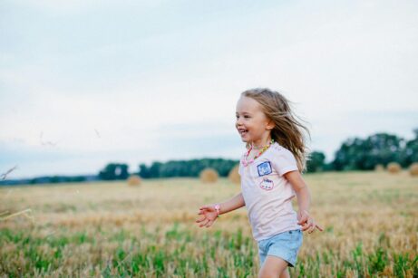 https://www.pexels.com/photo/smiling-girl-running-towards-left-on-green-field-220455/