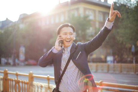 https://www.pexels.com/photo/cheerful-asian-businessman-chatting-on-phone-and-hailing-cab-3760814/