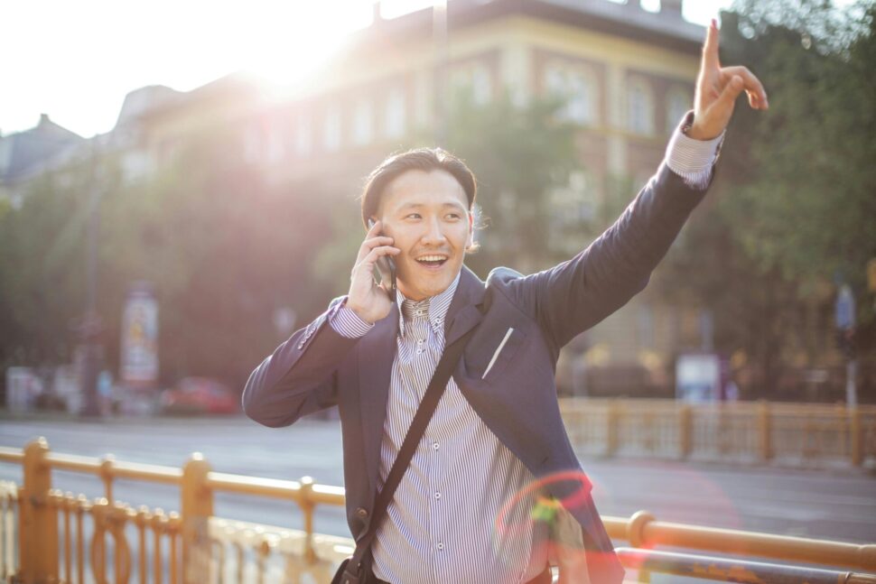 https://www.pexels.com/photo/cheerful-asian-businessman-chatting-on-phone-and-hailing-cab-3760814/