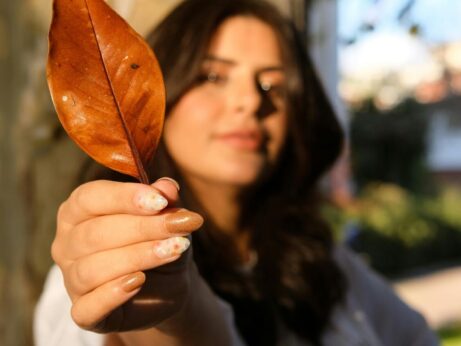 https://www.pexels.com/photo/woman-holding-autumn-leaf-in-sunny-outdoor-setting-29444971/