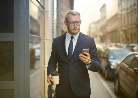 https://www.pexels.com/photo/selective-focus-photo-of-walking-man-in-black-suit-carrying-a-to-go-cup-and-briefcase-while-using-his-phone-3771076/