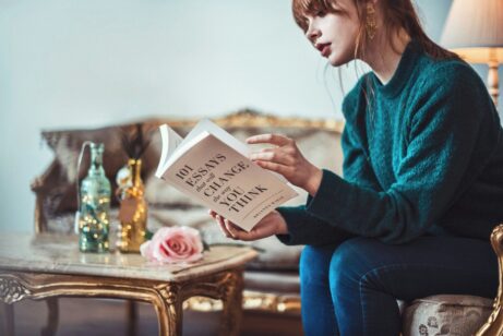 https://unsplash.com/photos/woman-sitting-down-near-table-reading-101-essays-book-nbkd_9UpSb0