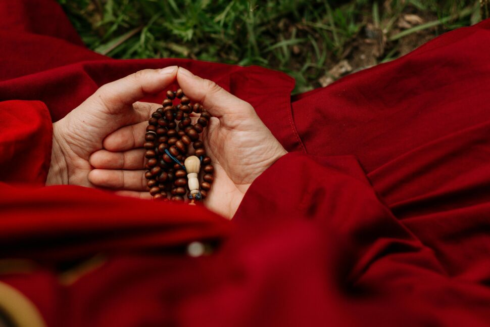https://www.pexels.com/photo/person-holding-red-and-black-beads-5386062/