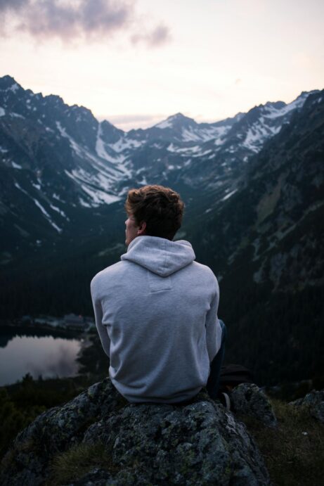 https://www.pexels.com/photo/a-man-in-white-hoodie-sitting-on-a-rock-across-the-mountains-93827/
